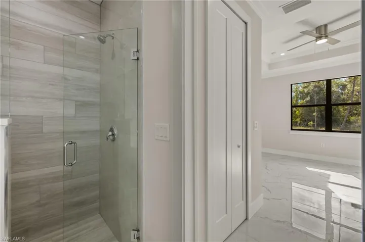 Bathroom featuring crown molding, ceiling fan, and a shower with shower door