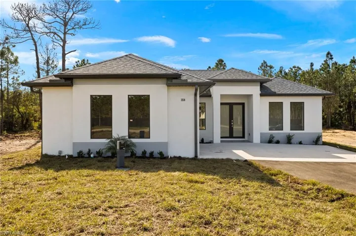 Rear view of property with a lawn, a patio area, and french doors