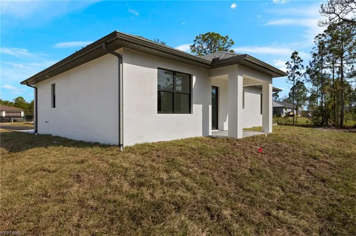 Rear view of house featuring a yard