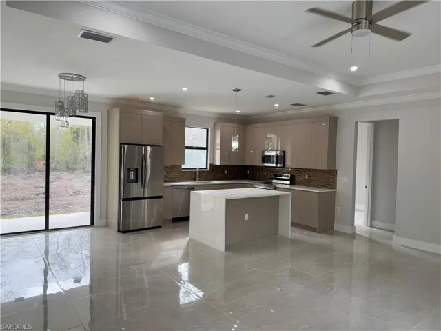 ACTUAL PROPERTY-Kitchen featuring gray cabinetry, a center island, pendant lighting, appliances with stainless steel finishes, and ornamental molding