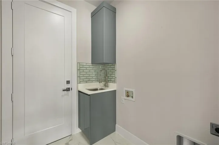 Laundry room featuring hookup for an electric dryer, cabinets, sink, and hookup for a washing machine