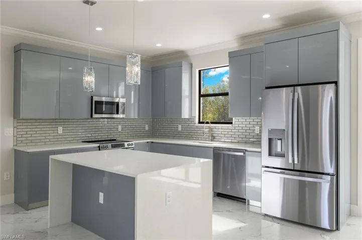 Kitchen featuring backsplash, a center island, stainless steel appliances, and sink