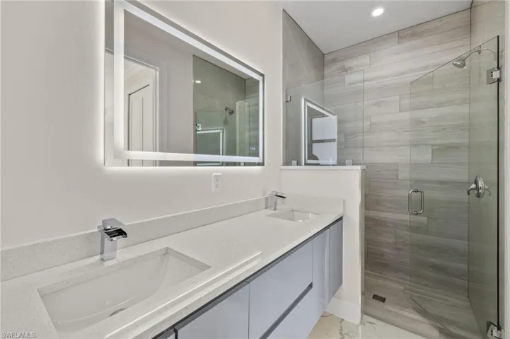 Bathroom featuring vanity and a shower with shower door