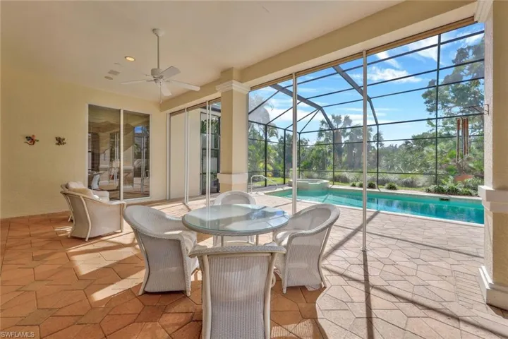 View of pool featuring ceiling fan and electric shutters
