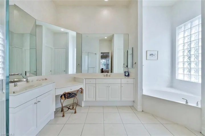 Bathroom with tile patterned flooring, vanity, and a healthy amount of sunlight