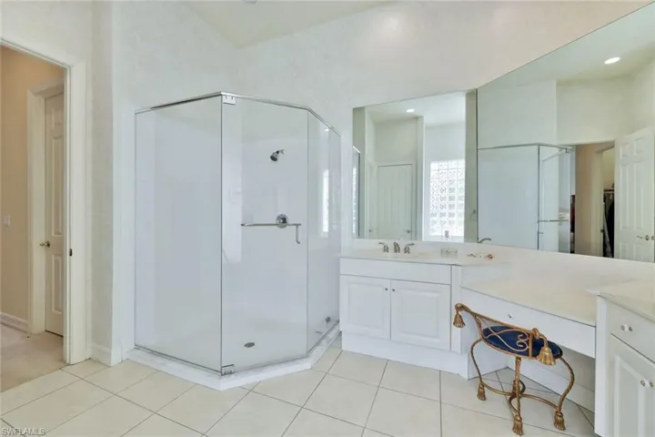 Bathroom with tile patterned flooring, vanity, and walk in shower