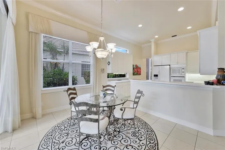 Dining space featuring a chandelier, light tile patterned floors, and ornamental molding