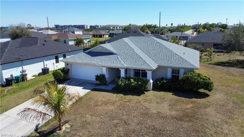 View of front of house featuring stucco siding, a residential view, roof with shingles, an attached garage, and a front yard