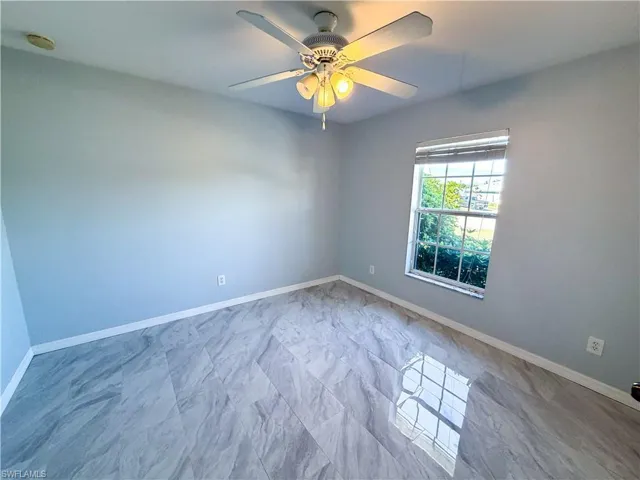 Unfurnished room with a ceiling fan and a smoke detector