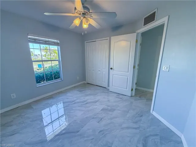 Unfurnished bedroom with ceiling fan and a closet