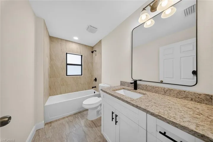 Full bath featuring vanity and bathing tub / shower combination