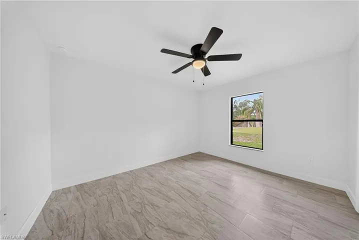 Unfurnished room featuring baseboards and ceiling fan