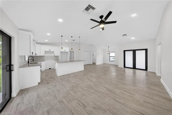 Unfurnished living room featuring a ceiling fan, lofted ceiling, and recessed lighting