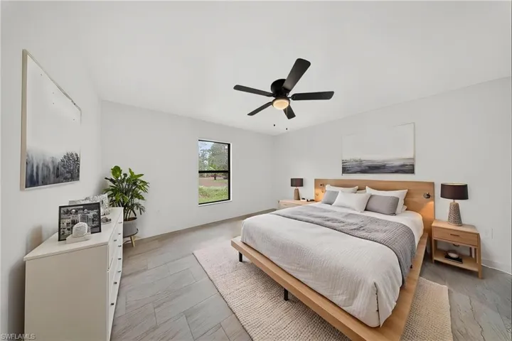 Bedroom with ceiling fan and light wood-style flooring