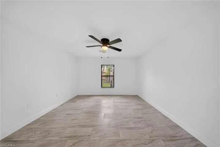 Empty room with ceiling fan and baseboards