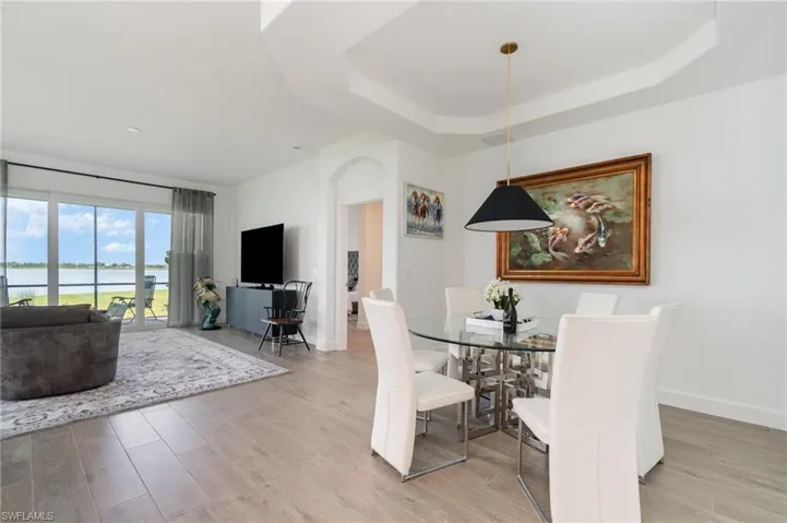 Dining area with a tray ceiling and light wood-style floors