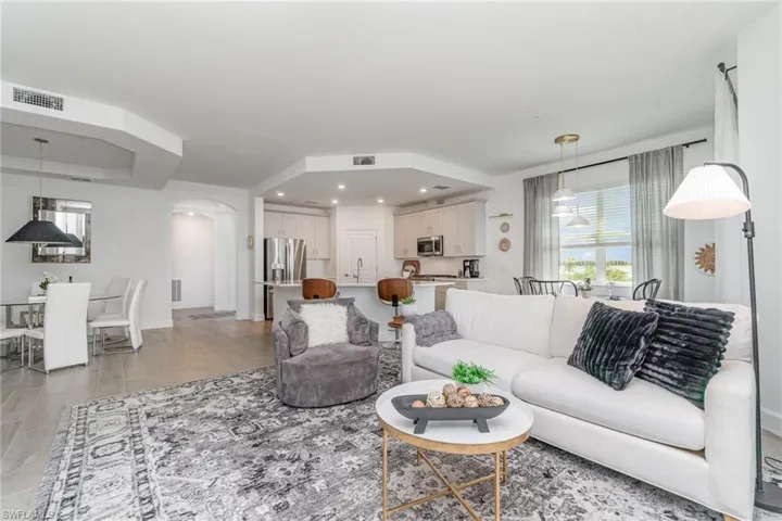 Living room with arched walkways, recessed lighting, and light wood-type flooring