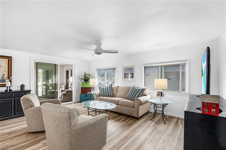 Living area featuring light wood-style flooring, a ceiling fan, and healthy amount of natural light