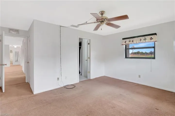 Unfurnished bedroom featuring light carpet, baseboards, and ceiling fan