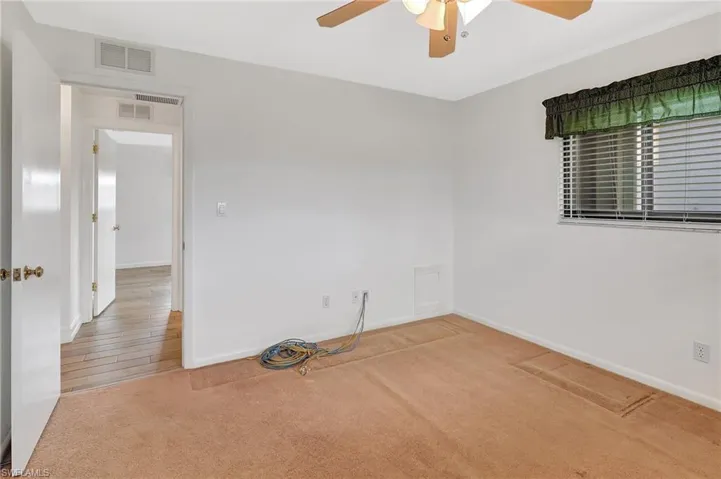 Spare room featuring ceiling fan, carpet flooring, and baseboards