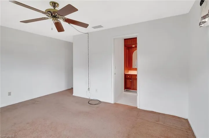 Spare room with light colored carpet, a ceiling fan, and baseboards