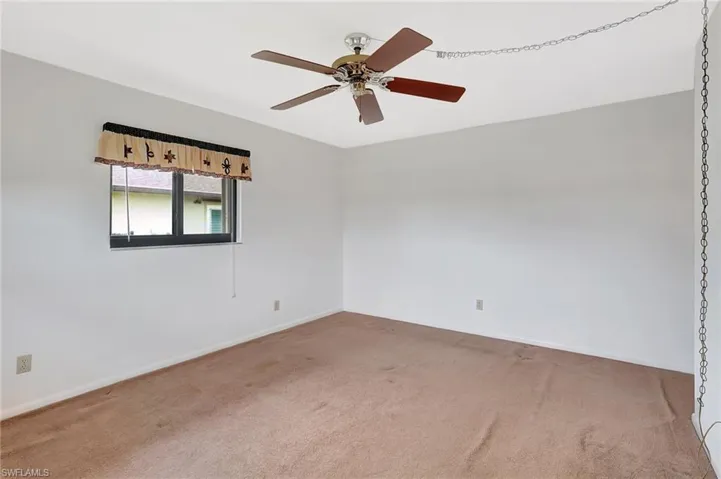 Unfurnished room with carpet flooring, baseboards, and ceiling fan