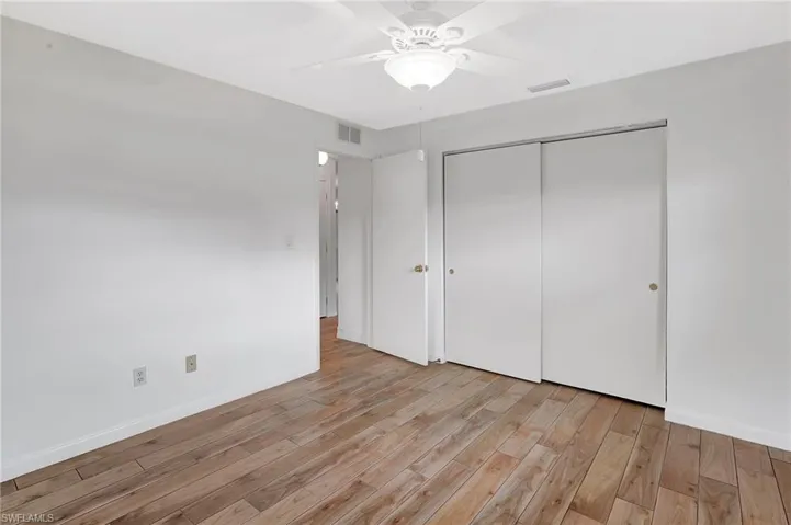 Unfurnished bedroom featuring light wood-type flooring, a closet, ceiling fan, and baseboards