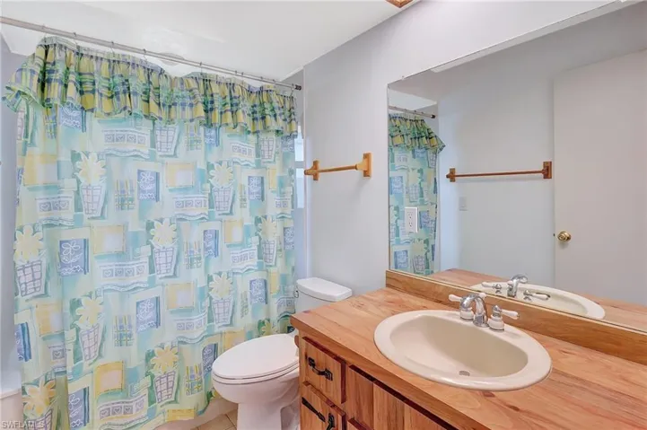 Full bath featuring toilet, vanity, and a shower with shower curtain