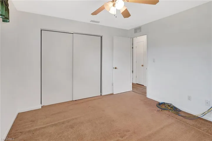 Unfurnished bedroom with carpet flooring, a closet, ceiling fan, and baseboards