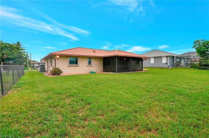 Back of property featuring a sunroom, central air condition unit, stucco siding, and metal roof