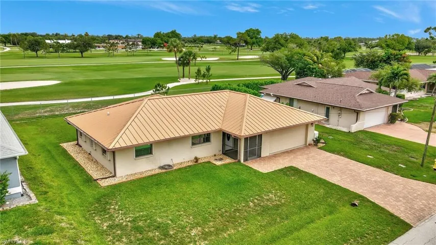 Aerial view of property and surrounding area featuring a golf club