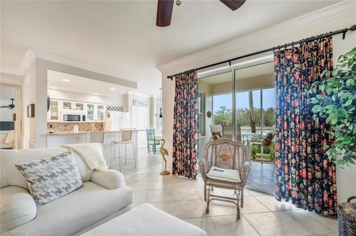 Living area featuring a ceiling fan, ornamental molding, light tile patterned flooring, and recessed lighting