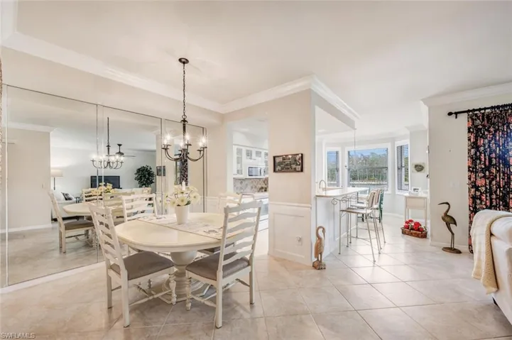 Dining space featuring ornamental molding, light tile patterned floors, and a chandelier