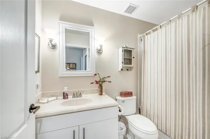 Bathroom featuring vanity and shower / bath combination with curtain