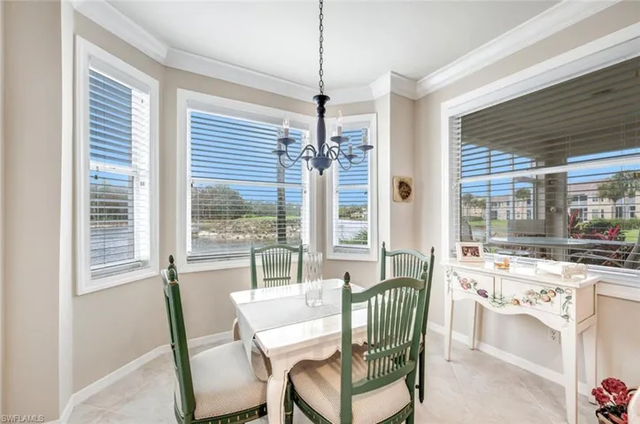 Dining area featuring crown molding, a chandelier, healthy amount of natural light, and light tile patterned floors