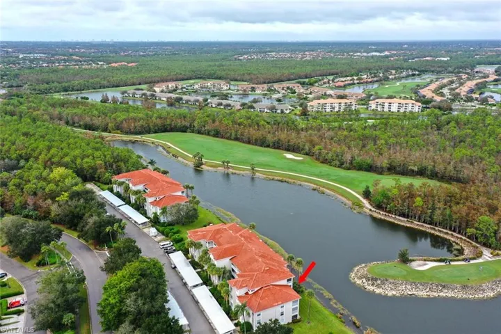 Drone / aerial view of a golf course and a nearby body of water