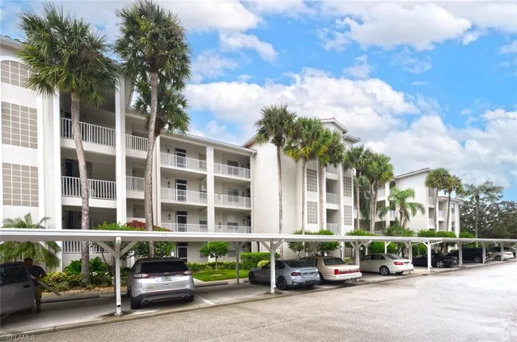View of apartment building / complex with covered parking