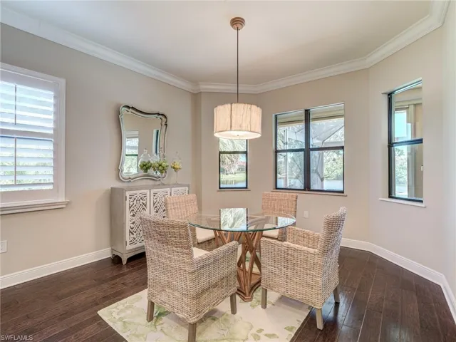 Breakfast room featuring ornamental molding and dark wood-style floors