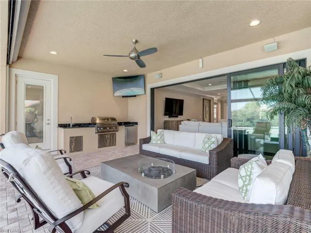 View of patio with an outdoor living space with a fire table, a ceiling fan, and an outdoor kitchen