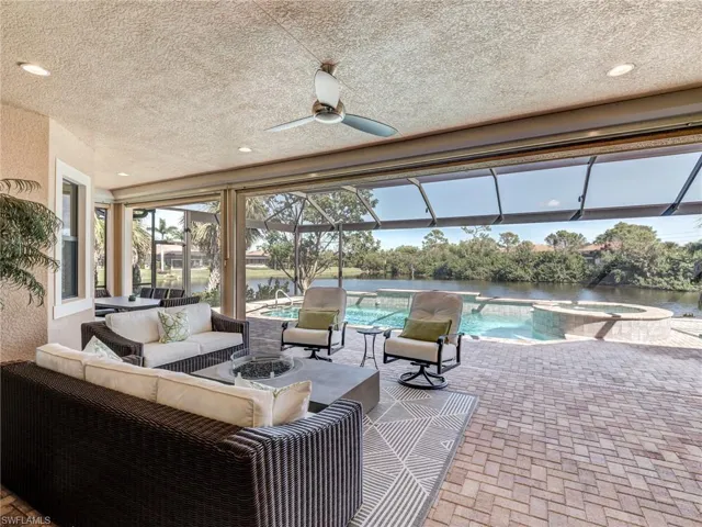 View of patio / terrace with a sunroom, ceiling fan, a lanai, an outdoor living space, and a pool with connected hot tub