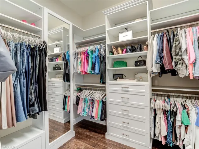 Custom Walk in closet featuring dark wood-type flooring