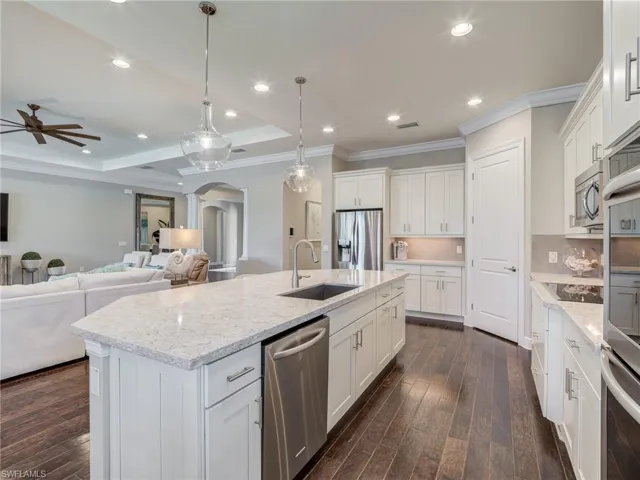Kitchen featuring arched walkways, hanging light fixtures, backsplash, recessed lighting, and stainless steel appliances