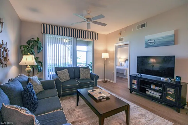 Living room with ceiling fan and hardwood / wood-style flooring