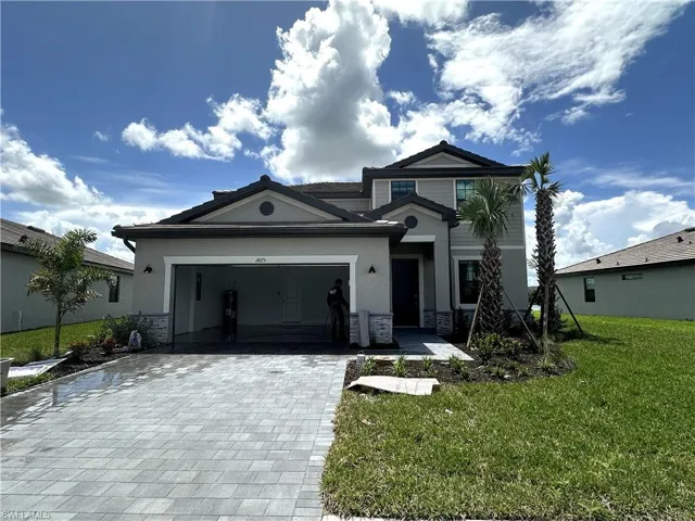 View of front of home featuring a garage and a front lawn