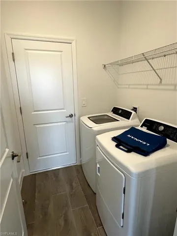 Washroom featuring dark hardwood / wood-style floors and washing machine and dryer