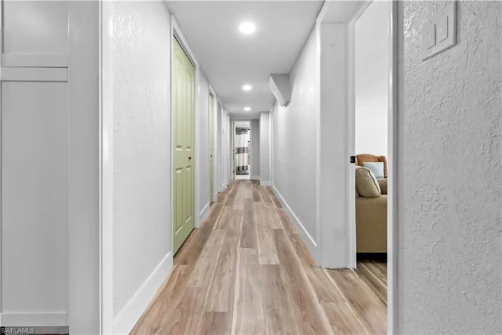 Hallway with bonus room to the right, bedrooms down the hallway and the guest bath at the end