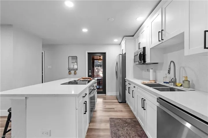 Kitchen featuring white cabinets, stainless steel appliances, a center island, a breakfast bar area, and Quartz counter tops