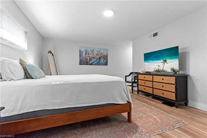 Bedroom with wood finished floors and baseboards