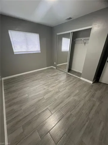 Unfurnished bedroom featuring hardwood / wood-style floors and a closet