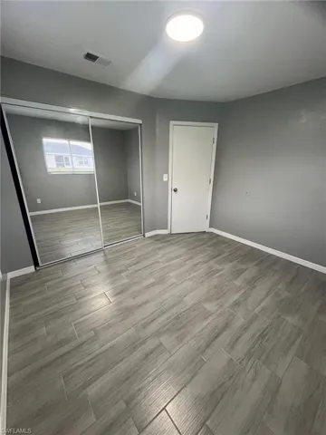 Unfurnished bedroom featuring hardwood / wood-style flooring and a closet